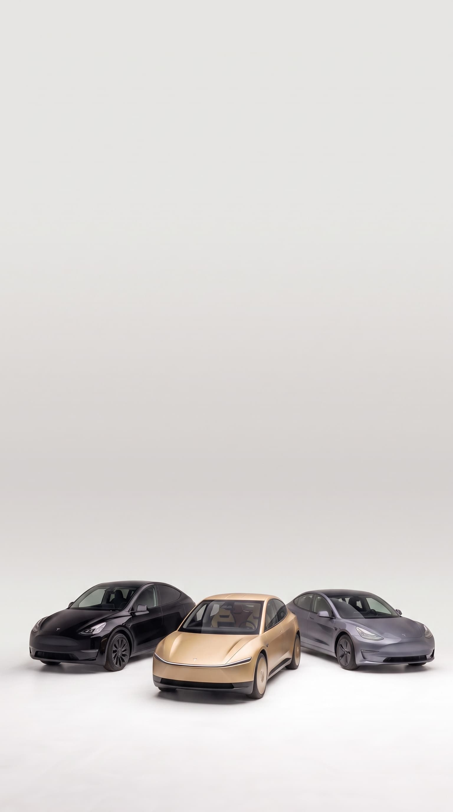 A Tesla Model Y, Cybercab and Model 3 together in a studio